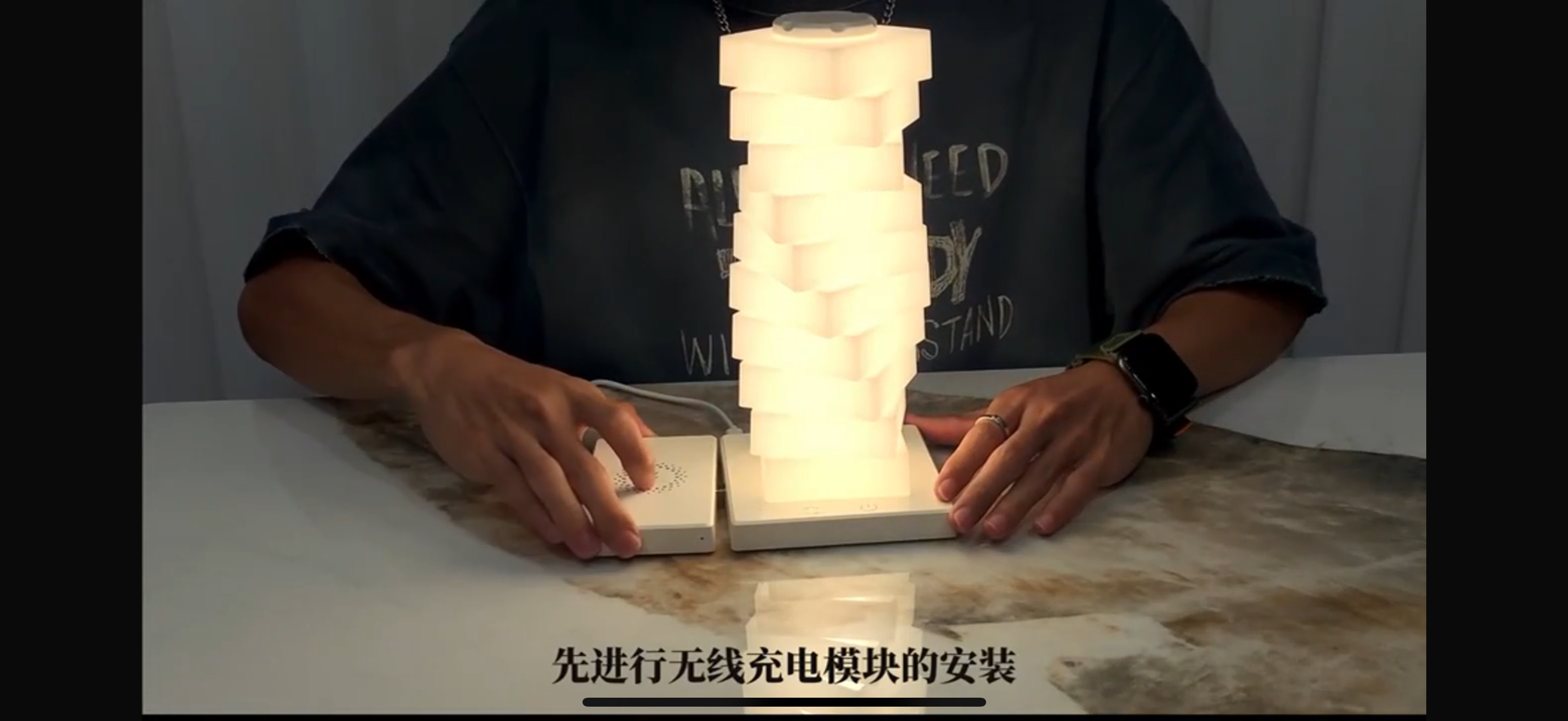 Person assembling a light-up model on a table with a neutral background